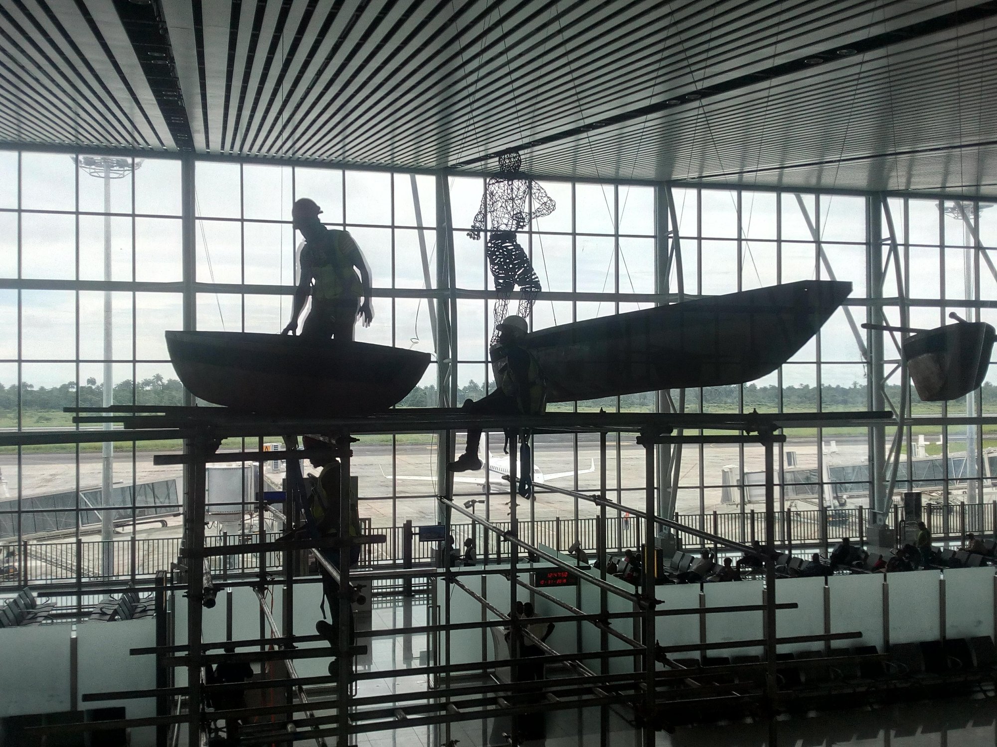 Fishing in the Sky (artist: Adeodunfa; designed and curated by Spacefinish): working from scaffolding on the canoes under the terminal roof.