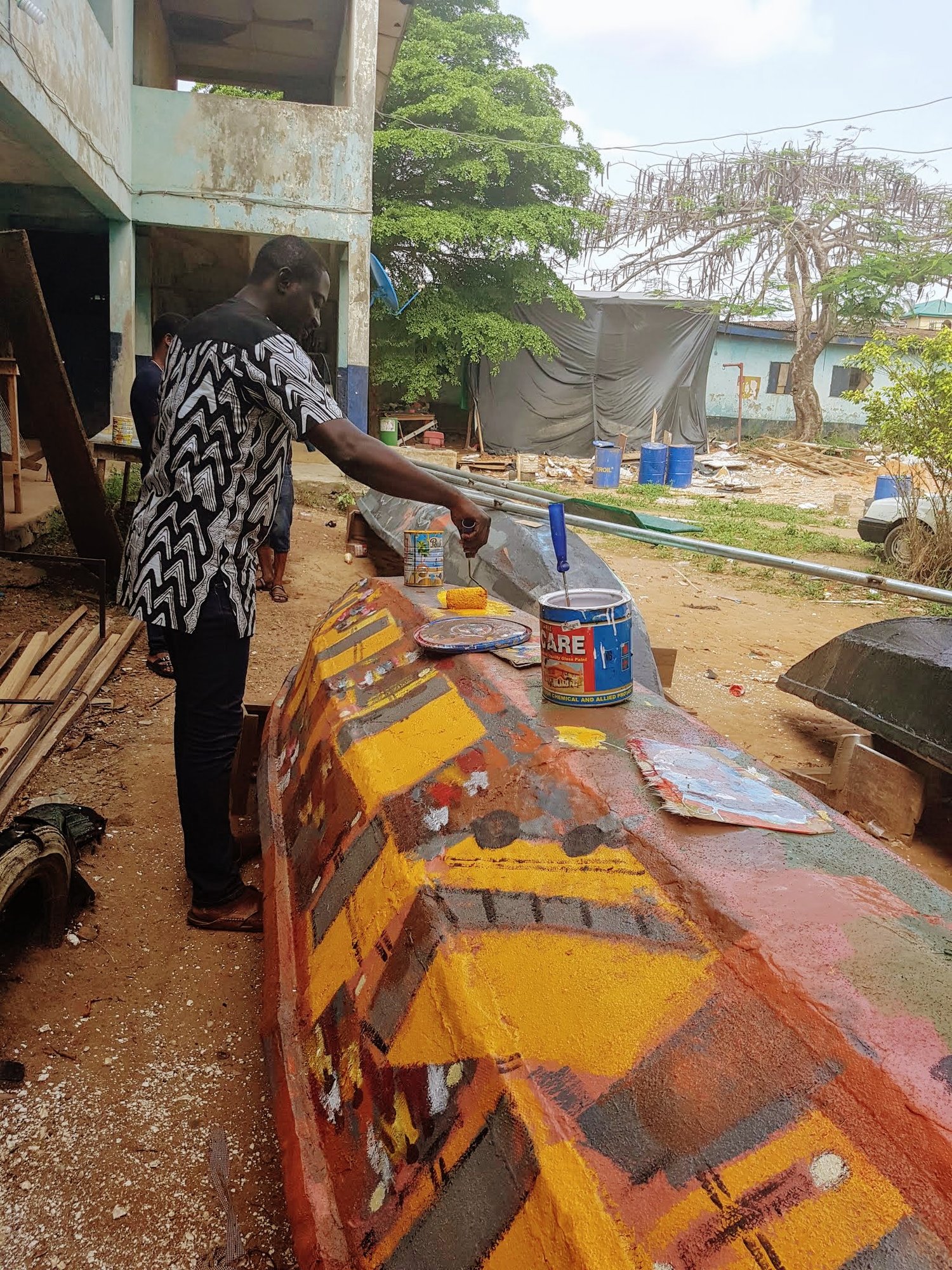 Painting a canoe hull in bright colours.